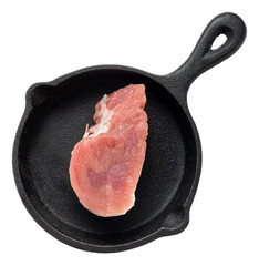 Raw pork fillet slice on black cast iron skillet with textured surface showcasing fresh, tender...
