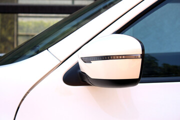 White rear view mirror of a white modern car. Car rear view mirror round oval shape. Side rear view...
