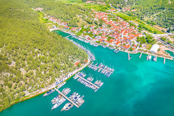 Aerial view of the charming town of Skradin, Croatia, featuring its picturesque marina filled with boats, traditional red-roofed houses, and lush natural surroundings