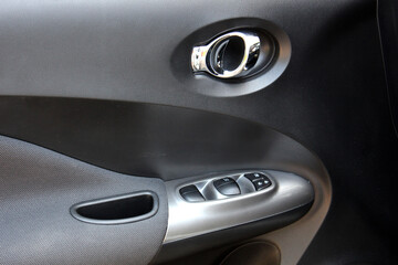 Passenger door trim. Door handle of modern car. New car windows control panel. Grey interior of the...