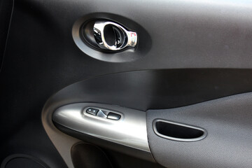 Passenger door trim. Door handle of modern car. New car windows control panel. Grey interior of the...
