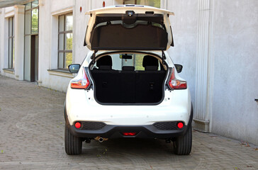 New white SUV open trunk. Modern electric car trunk.Vehicle is ready to load luggage. Modern car SUV with open empty trunk. Modern wagon car open trunk. Car boot is open.