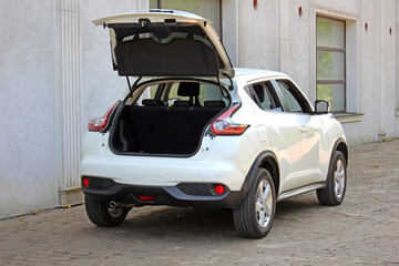 New white SUV open trunk. Modern electric car trunk.Vehicle is ready to load luggage. Modern car SUV with open empty trunk. Modern wagon car open trunk. Car boot is open.