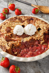 Chocolate strawberry cobbler with vanilla ice cream close-up in baking dish on table. Vertical