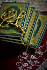 Holy quran and prayer beads on dark background
