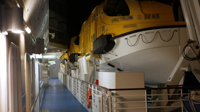 view on deck of passenger cruise ship travel on the deck of life boat while cruising in international open sea in night time, muster area on cruise ship