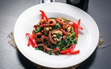 Stir-fried squid tentacles with bell peppers, spinach and garlic