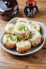 Shanghai style pan-fried buns on a porcelain plate