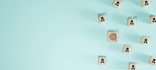 Wooden blocks with human icons connected by dotted lines and one block with a target symbol. Concept of target audience, marketing strategy, and business network.