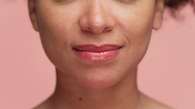 Close-up of woman puckering lips for kiss on pink