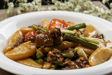 Braised pork with beans and yam fish on a white porcelain plate
