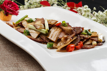 Stir-fried wild boar meat with rice, pepper and bamboo shoots on a white porcelain plate