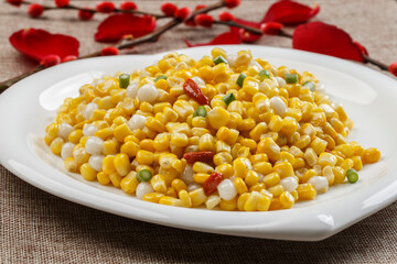 Corn with pine nuts on a white porcelain plate