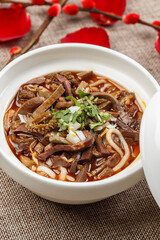 Spicy lamb and potato noodles in a white porcelain bowl
