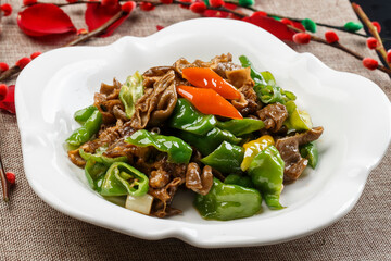 Stir-fried chicken gizzards with hot peppers on a white porcelain plate