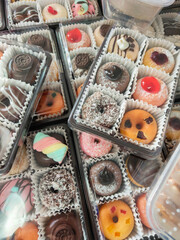 A delightful assortment of donuts, each adorned with colorful sprinkles, creamy frosting, and tempting chocolate glaze
