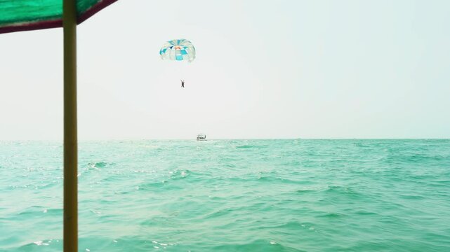 Traveler enjoy thrilling parasail ride in summer vacation