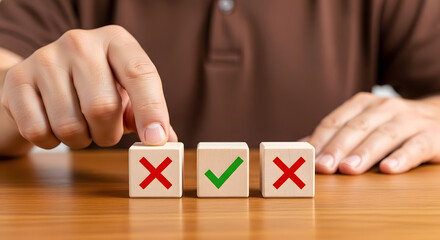 Hand placing a wooden block with a green checkmark between two blocks with red Xs, symbolizing decision-making or approval on a wooden surface.