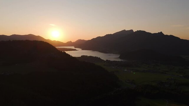 Aerial Drone Panoramic View, Sunset landscape at Lake Wolfgangsee and Strobl Town with Mountain Silhouettes