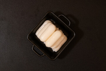Close-up of Tteokbokki Rice Cakes in a Black Square Dish