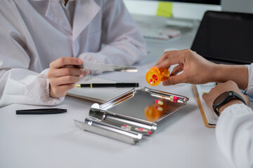 A doctor is handing a patient a pill bottle