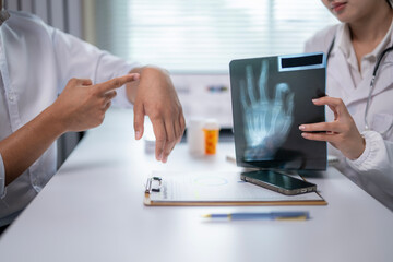 Two doctors are looking at a hand x-ray