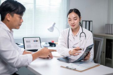 A doctor is showing a man a medical image on a computer screen