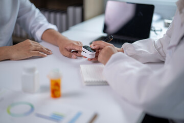 A doctor is showing a patient a device that measures blood pressure