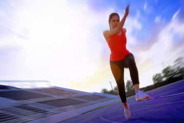 Silhouette of fit young woman running sprinting at the racetrack. Fit runner fitness runner during...