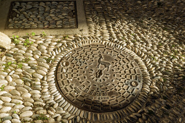 cast iron manhole cover with the coat of arms of the city of Rhodes, Greece