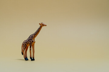 Toy giraffe on beige background as symbol of safety awareness. Plastic giraffe toy representing...