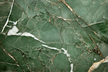 Natural green marble texture featuring vibrant streaks of white for elegant interior design elements