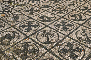 Decorative mosaic of finely arranged pebbles with a central motif decorated with symmetrical...