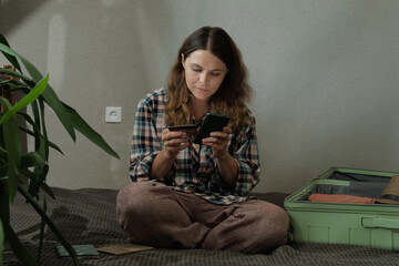 Online payment, booking a last minute tour. Woman paying for trip using bank card and smartphone