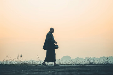 Silhouette of a Monk Walking at Sunrise