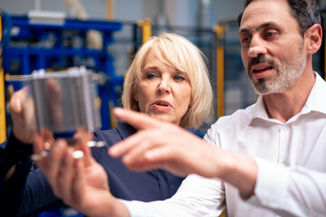 Businessman and businesswoman analyzing heating module in industry