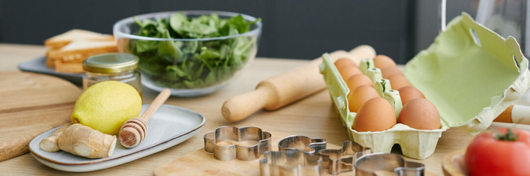 Healthy breakfast ingredients on a kitchen table with eggs, spinach, and baking tools