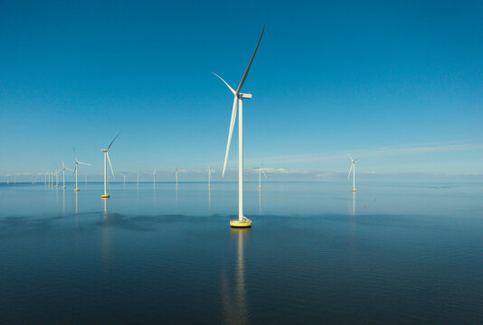 Offshore windfarm on a windless day in the Netherlands with calm sea and blue sky