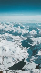 Fototapeta premium Snow-Covered Mountain Range with Winding River and Clear Blue Sky