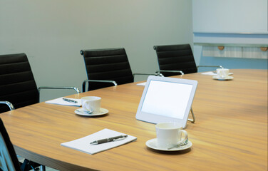A modern, empty conference room set for business on wooden table, arranged chairs, and neatly...