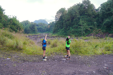 Asian Indonesian couple stretching before trail run, outdoor exercise and sustainable lifestyles