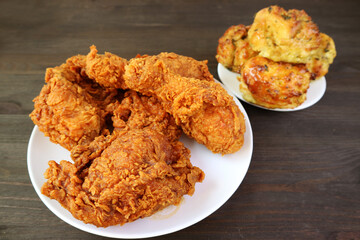 Closeup of Heap of Golden Brown Crunchy Fried Chickens with Blurry Biscuits in the Backdrop