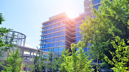 Sustainable glass office building with trees for reducing carbon dioxide. Eco-friendly building in...