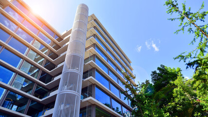 Sustainable glass office building with trees for reducing carbon dioxide. Eco-friendly building in...
