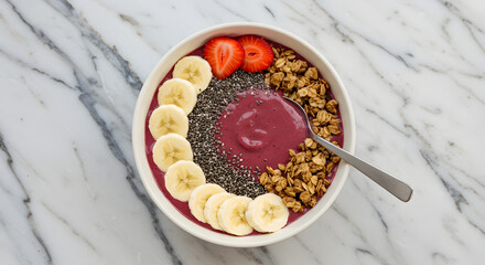 A vibrant smoothie bowl topped with fresh strawberries, banana slices, chia seeds, and granola.