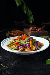 Chinese vegetarian meal: stir-fried bell peppers, beans, potatoes and eggplant