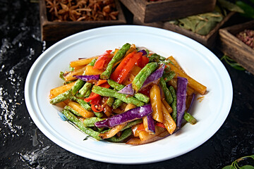Chinese vegetarian meal: stir-fried bell peppers, beans, potatoes and eggplant