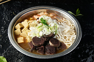Mongolian cuisine: blood sausage, roasted pork, frozen tofu and vermicelli stew