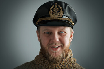Smiling captain in a brown sweater.