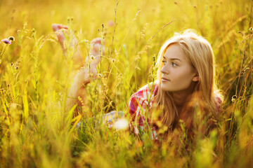 Happy girl in a field of grass and flowers.